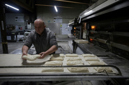 Jean-Pierre Delboulbe, boulanger et fondateur de la boulangerie Louboulbil, prépare du pain pour la cuisson dans son laboratoire à Castelsagrat, le 10 décembre 2024 dans le Tarn-et-Garonne