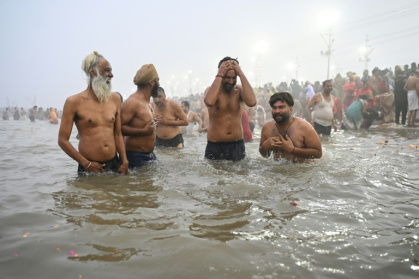 Des pèlerins hindous se baignent dans les eaux froides du confluent des fleuves sacrés du Gange, de la Yamuna et de la Sarasvati à Prayagraj en Inde, le 13 janvier 2025