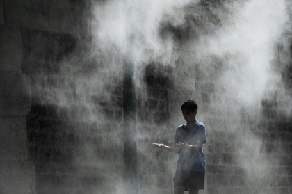 Un jeune garçon profite d'un brumisateur installé sur un quai de la Seine à Paris lors d'une canicule, le 25 juillet 2019 - PHILIPPE LOPEZ (AFP) Un jeune garçon profite d'un brumisateur installé sur un quai de la Seine à Paris lors d'une canicule, le 25 juillet 2019 - PHILIPPE LOPEZ (AFP)