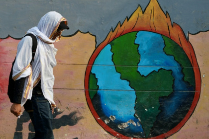 Un passant marche devant une peinture murale en pleine vague de chaleur à Varanasi, en Inde, le 9 juin 2025 - Ioana PLESEA, Julie PEREIRA, Sabrina BLANCHARD (AFP)