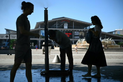 Des personnes se rafraîchissent à une fontaine publique près de la Grande Halle de La Villette alors qu'une vague de chaleur frappe le sud de l'Europe, à Paris, le 29 juin 2025 - Julie SEBADELHA (AFP)