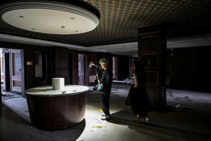 Xu Pengcheng (G) et Mao Yi lors d'une séance d'exploration urbaine dans un hôtel désaffecté de Shanghai, le 24 mai 2025 - Hector RETAMAL (AFP)