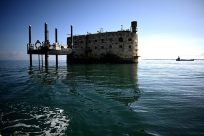 Une barge effectue des travaux de terrassement à proximité du Fort Boyard qui menace de s'écrouler, au large de l'île d'Aix dans l'océan Atlantique, le 16 juillet 2025 en Charente-Maritime - Christophe ARCHAMBAULT (AFP)