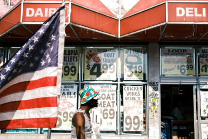 Une personne passe devant une épicerie et un drapeau américain dans le quartier de Flatbush, surnommé "Little Haiti", dans l'arrondissement de Brooklyn à New York, aux Etats-Unis, le 15 juillet 2025 - CHARLY TRIBALLEAU (AFP) Une personne passe devant une épicerie et un drapeau américain dans le quartier de Flatbush, surnommé "Little Haiti", dans l'arrondissement de Brooklyn à New York, aux Etats-Unis, le 15 juillet 2025 - CHARLY TRIBALLEAU (AFP)
