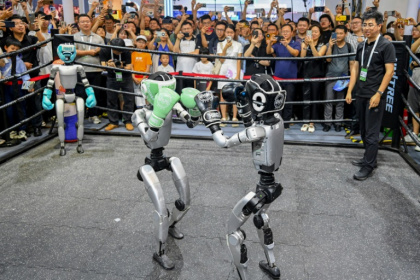 Des visiteurs regardent un combat de boxe entre robots lors de la World AI Conference (WAIC), le 26 juillet 2025 à Shanghai - - (AFP) Des visiteurs regardent un combat de boxe entre robots lors de la World AI Conference (WAIC), le 26 juillet 2025 à Shanghai - - (AFP)