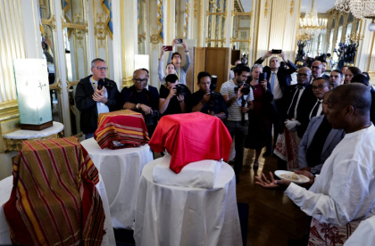 Un homme bénit trois crânes lors d'une cérémonie pour leur restitution à Madagascar, au ministère de la Culture à Paris, le 26 août 2025 - STEPHANE DE SAKUTIN (AFP)