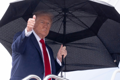 Le président américain Donald Trump tient un parapluie et lève le pouce alors qu'il monte à bord d'Air Force One avant son départ de la base aérienne d'Andrews, près de Washington, le 12 octobre 2025 - Eyad BABA (AFP) Le président américain Donald Trump tient un parapluie et lève le pouce alors qu'il monte à bord d'Air Force One avant son départ de la base aérienne d'Andrews, près de Washington, le 12 octobre 2025 - Eyad BABA (AFP)