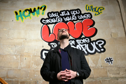 Le poète Alex Vellis, devant des graffitis de l'exposition "Hear us" ("Entends-nous"), sur les murs de la cathédrale de Canterbury (sud de l'Angleterre) le 16 octobre 2025 - Ben STANSALL (AFP) Le poète Alex Vellis, devant des graffitis de l'exposition "Hear us" ("Entends-nous"), sur les murs de la cathédrale de Canterbury (sud de l'Angleterre) le 16 octobre 2025 - Ben STANSALL (AFP)
