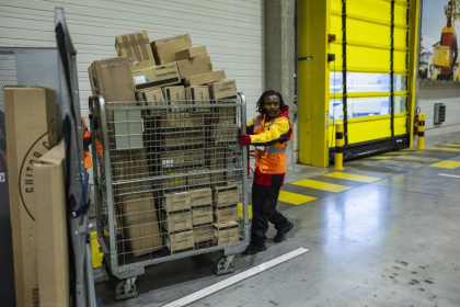 Un employé pousse un conteneur de colis dans un entrepôt DHL à Lesquin, près de Lille, le 12 novembre 2025 - Sameer Al-DOUMY (AFP)