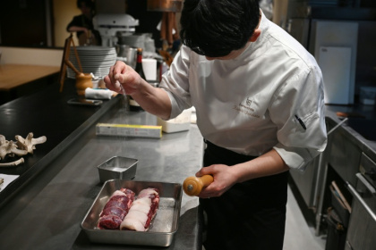 Le chef Kiyoshi Fujimoto cuisine de la viande d'ours dans son restaurant de Sapporo, dans la région d'Hokkaido, au Japon, le 9 décembre 2025 - GREG BAKER (AFP)