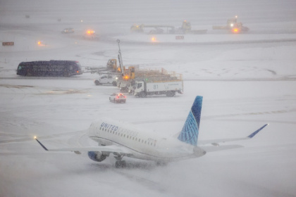 Un avion sur le tarmac enneigé de l'aéroport de LaGuardia à New York, le 25 janvier 2026 - CHARLY TRIBALLEAU (AFP)