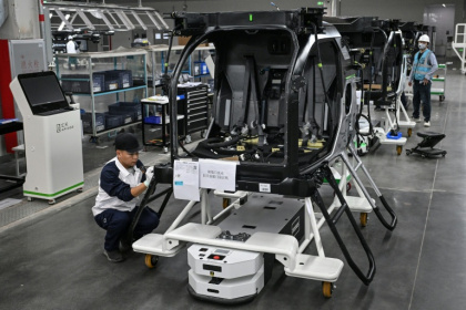Des employés travaillent sur une chaîne de montage pour la voiture volante électrique "Land Aircraft Carrier" dans une usine de la filiale Aridge de Xpeng à Guangzhou, dans le sud de la Chine, le 6 novembre 2025 - Jade GAO (AFP)