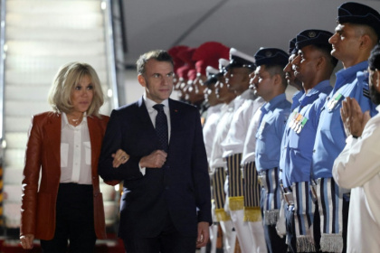 Le président français Emmanuel Macron (au centre à d.) et son épouse Brigitte Macron (à g.) sont accueillis par des responsables indiens à leur arrivée à Bombay, en Inde, le 17 février 2026 - Ludovic MARIN (AFP)