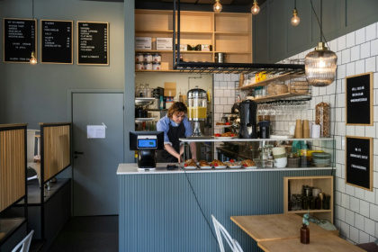 Kajetan Grzelczak derrière son comptoir  au café Andon à Stockholm, entièrement dirigé par l'IA, le 27 avril 2026 - Jonathan NACKSTRAND (AFP)