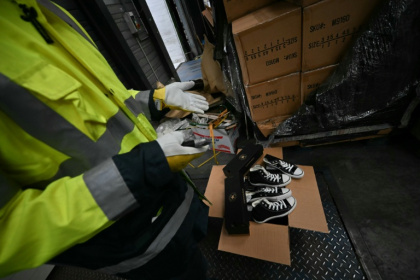 Un agent des douanes inspecte des chaussures contrefaites au Havre, en Seine-Maritime, le 3 juin 2026 - Lou BENOIST (AFP)