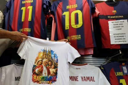 Un t-shirt orné d'une image du pape Léon XIV dans une boutique de souvenirs située à côté de la cathédrale de la Sagrada Familia, à la veille de sa visite à Barcelone le 7 juin 2026 - LLUIS GENE (AFP)