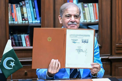 Le Premier ministre pakistanais Shehbaz Sharif montre le protocole d'accord signé par les présidents américain et iranien, après l'avoir lui-même signé en tant que médiateur, le 18 juin 2026 à Islamabad - MAHMOUD ZAYYAT (AFP)