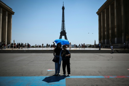 Des touristes se protègen du soleil au Trocadéro à Paris, le 18 juin 2026 - ROMAIN PERROCHEAU (AFP)