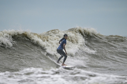 La surfeuse bangladaise Fatima Akhter pratique son sport à Cox's Bazar, dans le sud-est du Bangladesh, le 22 juin 2026 - Munir UZ ZAMAN (AFP)