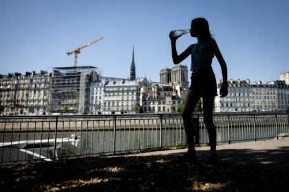 Une jeune femme s'hydrate pendant la canicule, le 24 juin 2026 à Paris - Simon WOHLFAHRT (AFP)